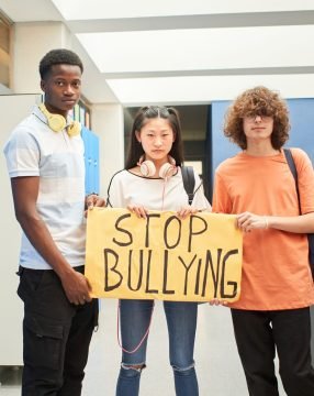 A group of students display a banner with the phrase: Stop Bullying.